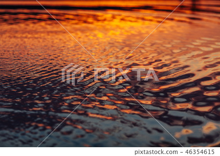 Water background with smooth ripples during sunset Water background with smooth ripples during sunset 46354615