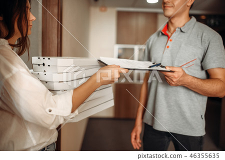 Customer takes order on pizza from delivery man 46355635