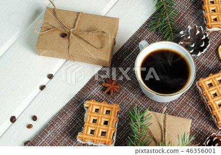 Cup of hot coffee with pastry, new year packs and pine cones 46356001