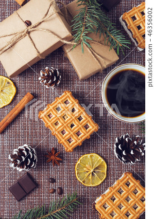Cup of hot coffee with pastry, new year packs and pine cones Cup of hot coffee with pastry, new year packs and pine cones 46356002