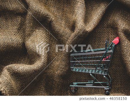 Shopping cart on jute background Shopping cart on jute background 46358150