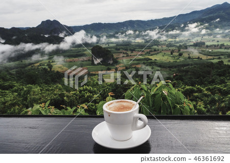 coffee cup on table with Mountain in the morning coffee cup on table with Mountain in the morning 46361692