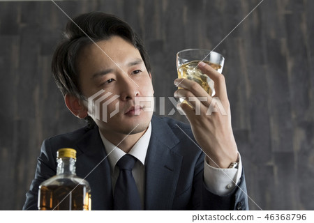 Businessman drinking whiskey Businessman drinking whiskey 46368796