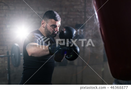 Young man hitting punching bag during training 46368877