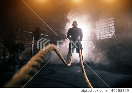 Young man doing hard exercise workout in gym Young man doing hard exercise workout in gym 46368899