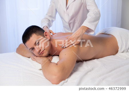a massage therapist makes therapeutic massage of hands and neck in Spa 46372999