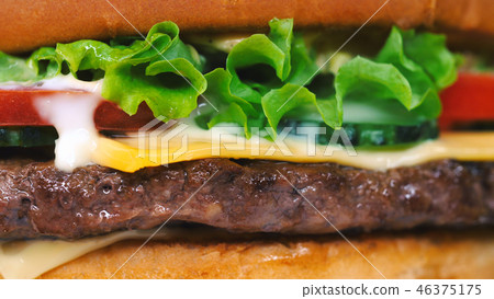 Yummy fast food concept. Fresh homemade grilled burger with meat patty, tomatoes, cucumber, lettuce 46375175