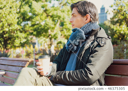 Man drinking coffee on a bench Man drinking coffee on a bench 46375305