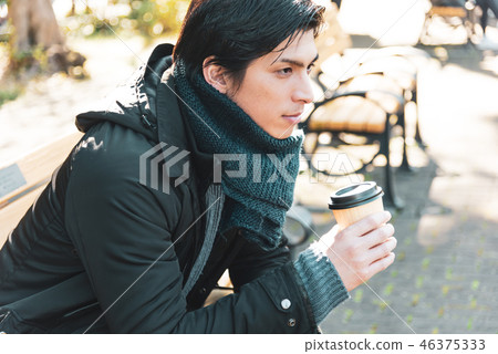 Winter young man drinking coffee outdoor 46375333