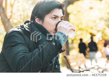 Winter young man drinking coffee outdoor Winter young man drinking coffee outdoor 46375339