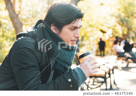 Winter young man drinking coffee outdoor Winter young man drinking coffee outdoor 46375340