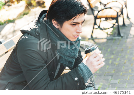 Winter young man drinking coffee outdoor Winter young man drinking coffee outdoor 46375341