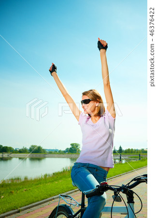Young woman is sitting on her bicycle Young woman is sitting on her bicycle 46376422