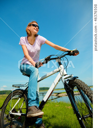 Young woman is sitting on her bicycle Young woman is sitting on her bicycle 46376508