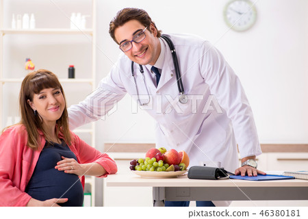 Pregnant woman visiting doctor discussing healthy diet 46380181