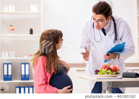 Pregnant woman visiting doctor discussing healthy diet 46380182