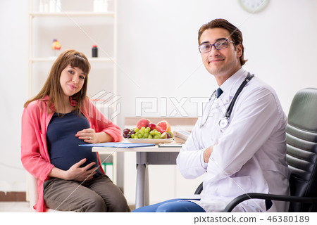 Pregnant woman visiting doctor discussing healthy diet 46380189