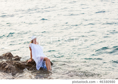 Attractive woman on a rocky sea shore Attractive woman on a rocky sea shore 46380980