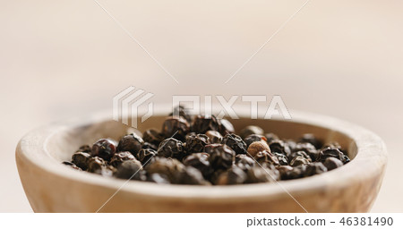 Closeup   of black dry pepper in wooden bowl on table 46381490