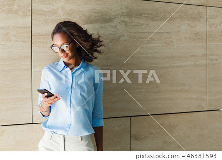 African smiling woman standing by the wall  46381593