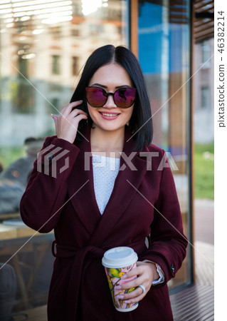 Pretty woman laughing and enjoying hot beverage in park 46382214