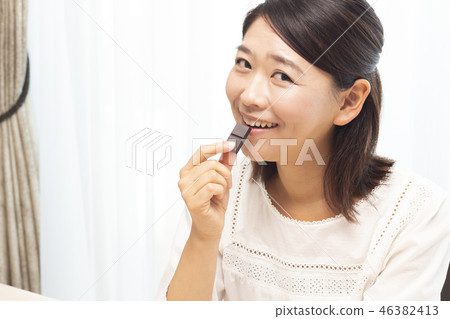 A woman eating chocolate 46382413