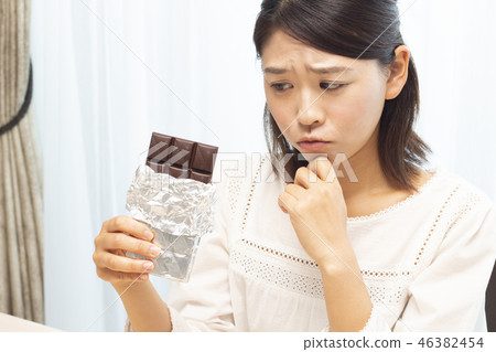 A woman eating a plate of chocolate 46382454
