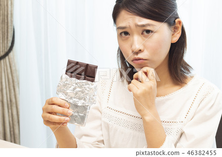 A woman eating a plate of chocolate 46382455
