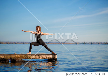 Young woman practicing yoga exercise at quiet pier Young woman practicing yoga exercise at quiet pier 46383101