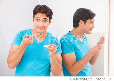 Man trying contact lenses at home Man trying contact lenses at home 46385925