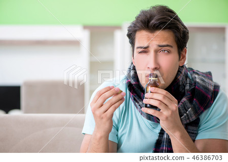 Young handsome man suffering from illness at home Young handsome man suffering from illness at home 46386703