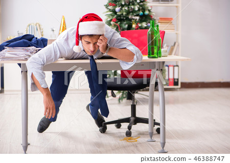 Young handsome employee celebrating Christmas at workplace Young handsome employee celebrating Christmas at workplace 46388747