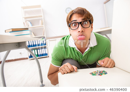 Office prank with sharp thumbtacks on chair 46390400