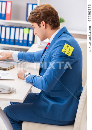 Office prank with kick me message on sticky note 46390576