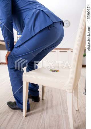 Office prank with sharp thumbtacks on chair 46390674