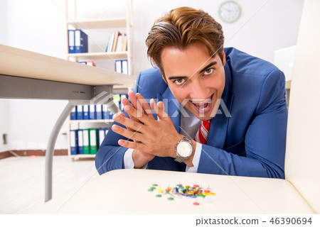 Office prank with sharp thumbtacks on chair 46390694