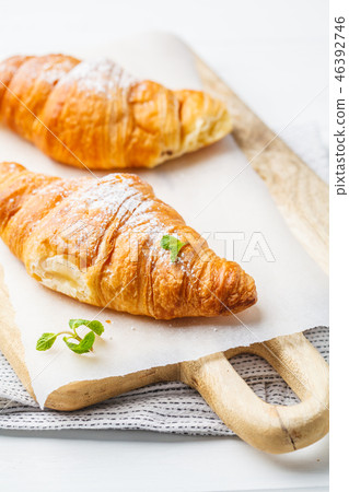 Fresh croissants on white wooden background. 46392746
