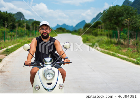 Traveler riding motorbike on Asian trip Traveler riding motorbike on Asian trip 46394081