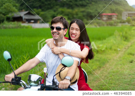 Couple having fun on motorbike around rice fields in China Couple having fun on motorbike around rice fields in China 46394085