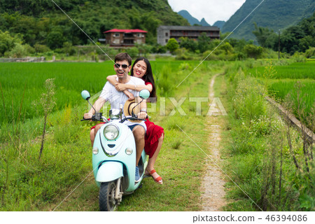 Couple riding motorbike around rice fields of Yangshuo, China Couple riding motorbike around rice fields of Yangshuo, China 46394086