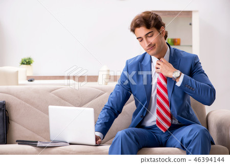 Young businessman working at home sitting on the sofa Young businessman working at home sitting on the sofa 46394144