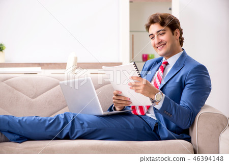 Young businessman working at home sitting on the sofa Young businessman working at home sitting on the sofa 46394148