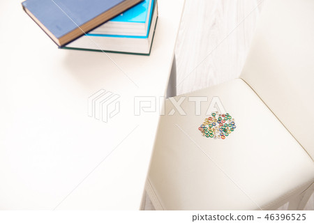 Office prank with sharp thumbtacks on chair 46396525