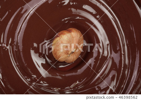 Melted chocolate swirl with hazelnut as a background closeup Melted chocolate swirl with hazelnut as a background closeup 46398562