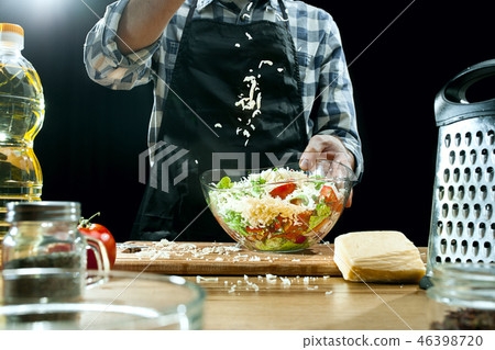 Preparing salad. Female chef cutting fresh vegetables. Cooking process. Selective focus Preparing salad. Female chef cutting fresh vegetables. Cooking process. Selective focus 46398720