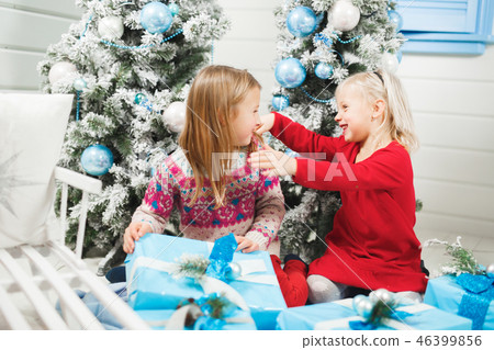 Happy little kids opening presents on Christmas eve Happy little kids opening presents on Christmas eve 46399856