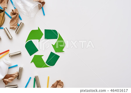 Think about ecology. Crumple paper, plastic and batteries near recycle symbol 46401617