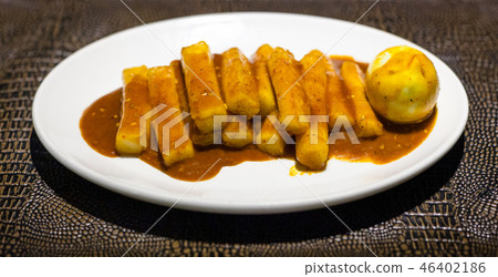 Tteok bokki on white plate on leathed board Tteok bokki on white plate on leathed board 46402186