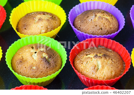 few baked cupcakes in multicolour silicone molds 46402207