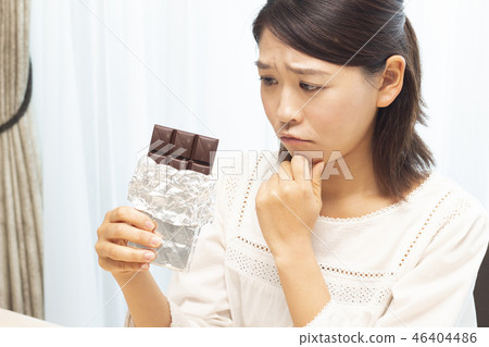 A woman eating a plate of chocolate A woman eating a plate of chocolate 46404486